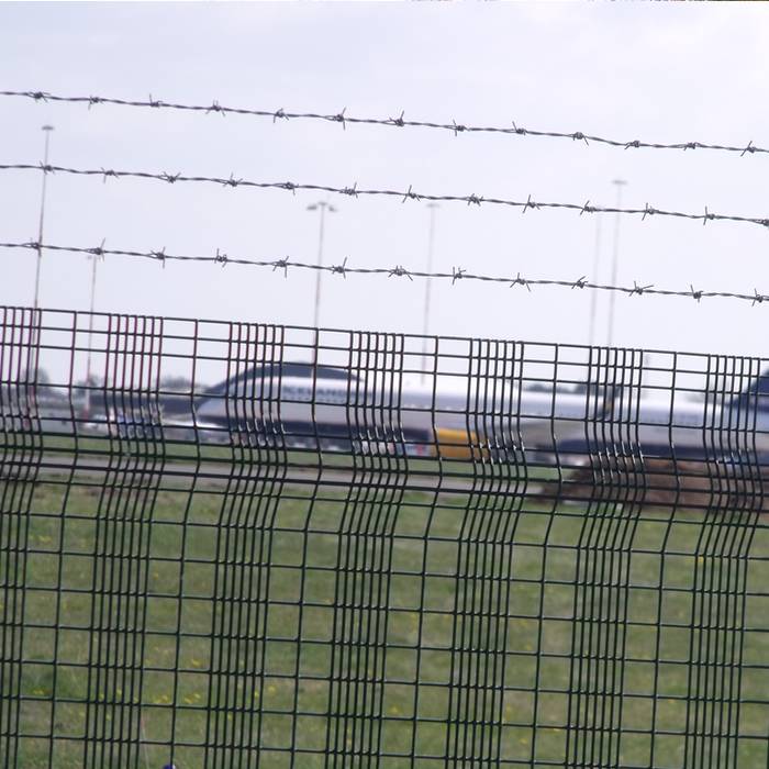 Trois lignes de barbelés sont installées au sommet de la clôture de l'aéroport.