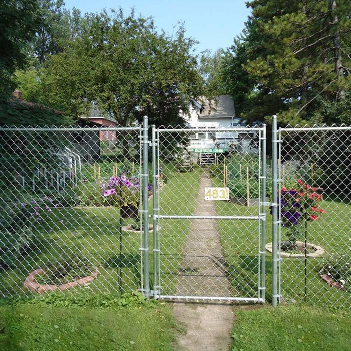 Un morceau de porte battante unique à mailles de chaîne est installé dans le jardin.