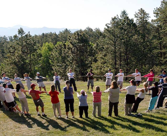 La gente se toma de la mano en círculo para realizar actividades al aire libre.